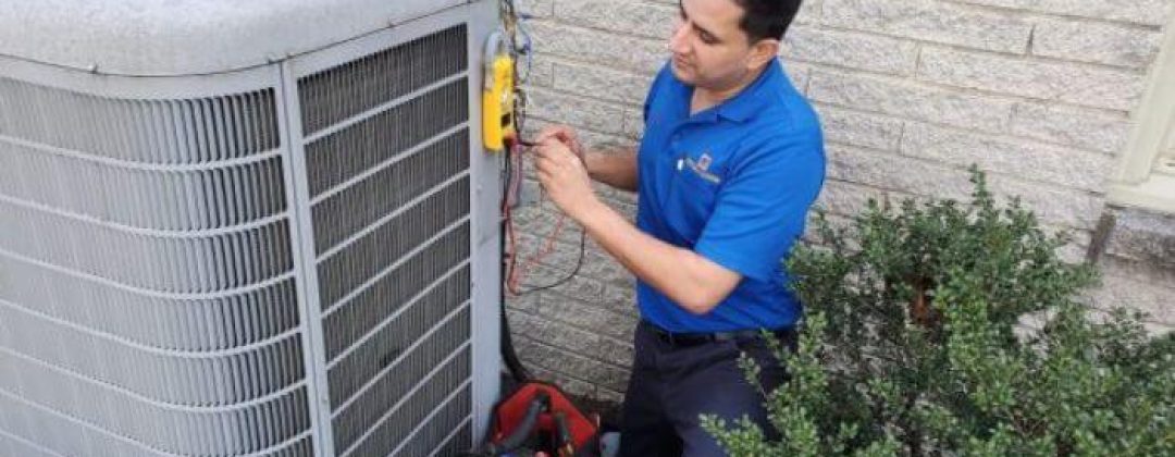 ac technician working on outdoor unit beside home